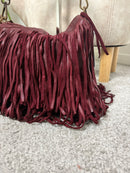 Borsa in pelle bordeaux con frange a spalla e tracolla